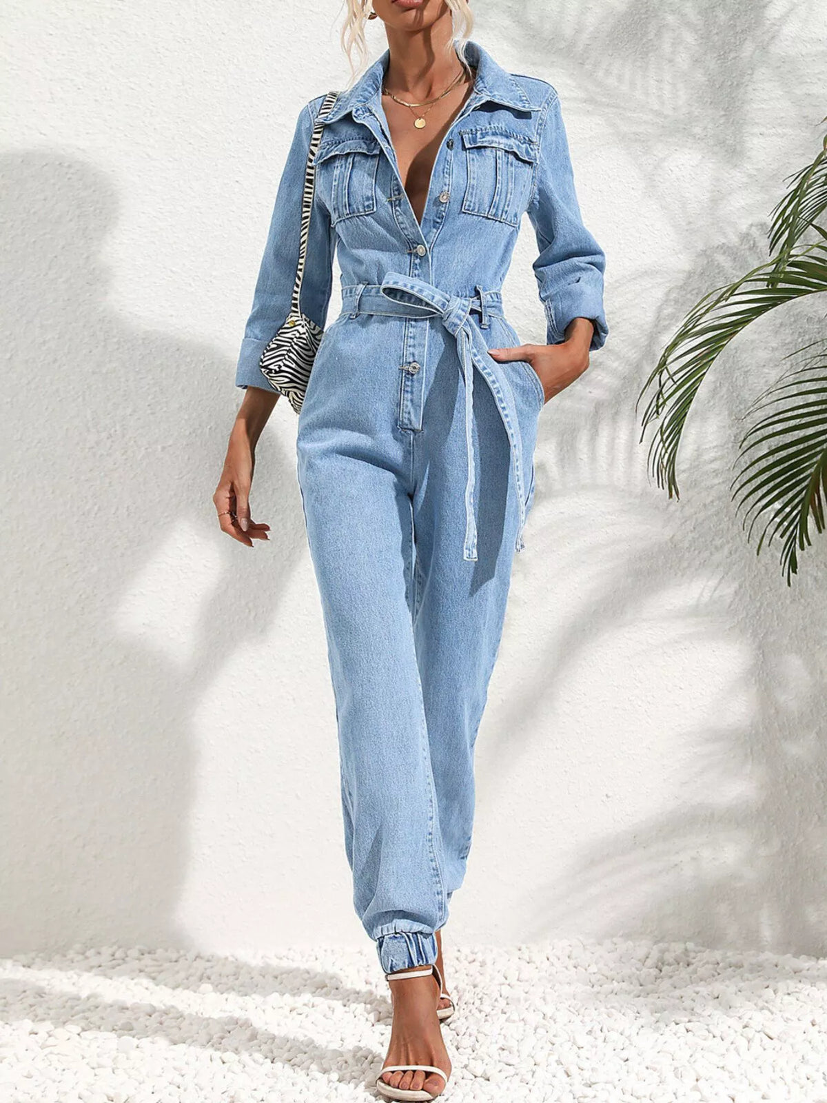 Medium blue denim button-front jumpsuit with waist tie belt and chest pockets