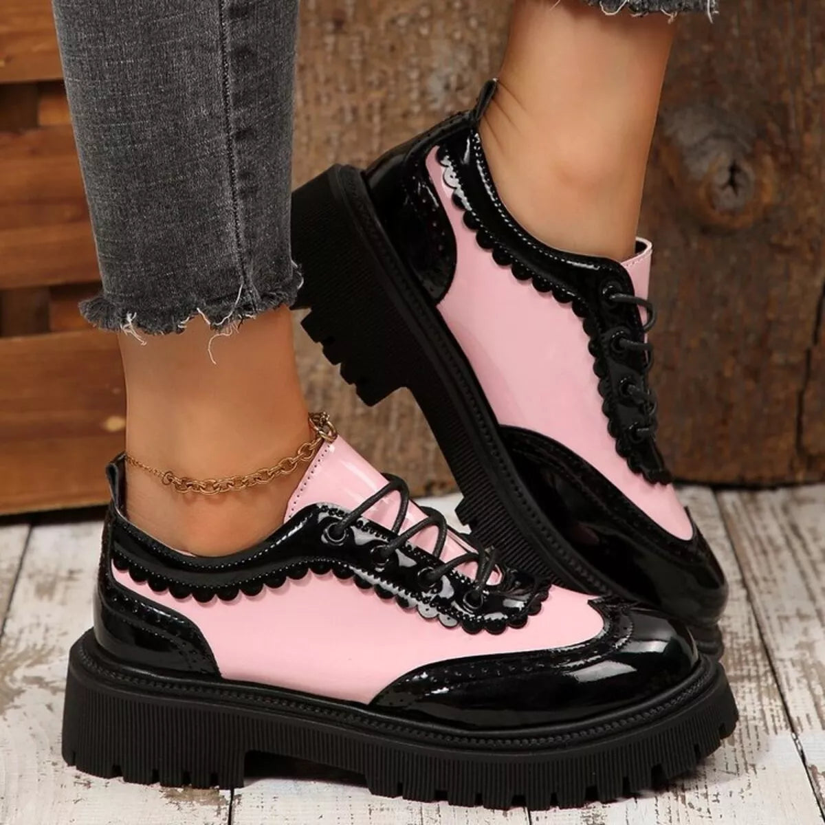 Pink and black platform loafers with lace-up front, scalloped trim, thick tread