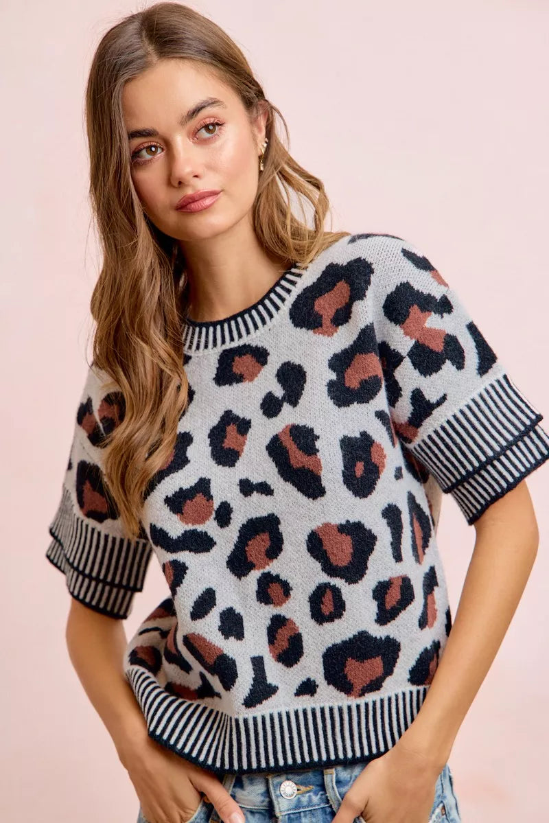 Leopard print knit top with black-and-white striped crew neckline and sleeve cuffs.