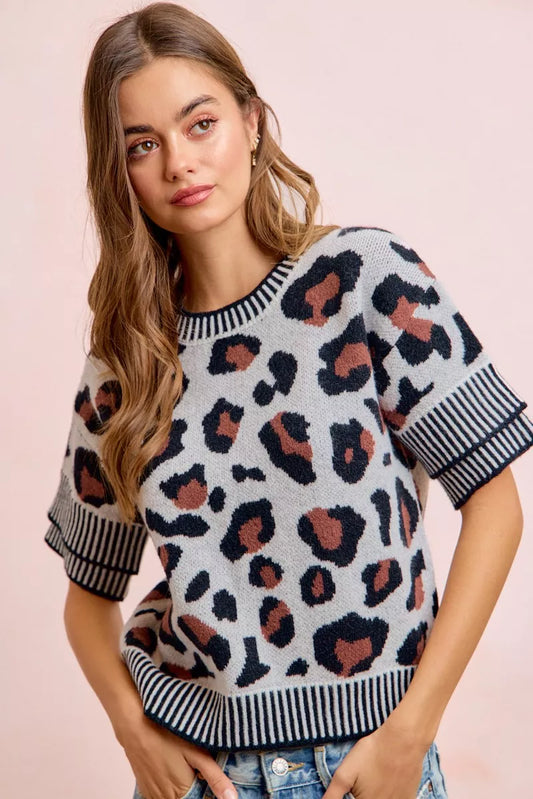 Leopard print knit top with black-and-white striped crew neckline and sleeve cuffs.