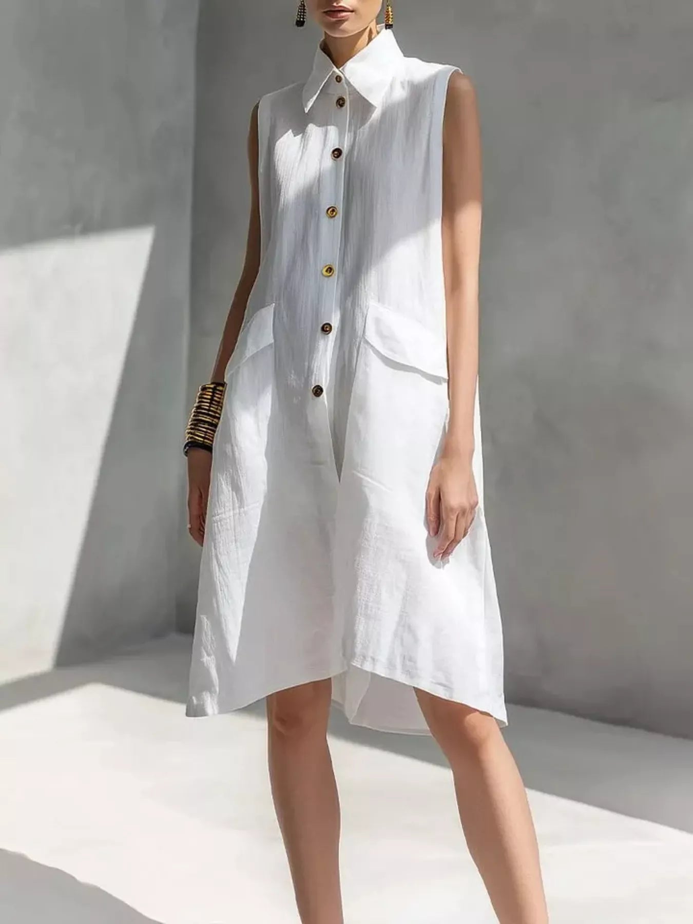White sleeveless button-front dress with pointed collar and patch pockets, knee length