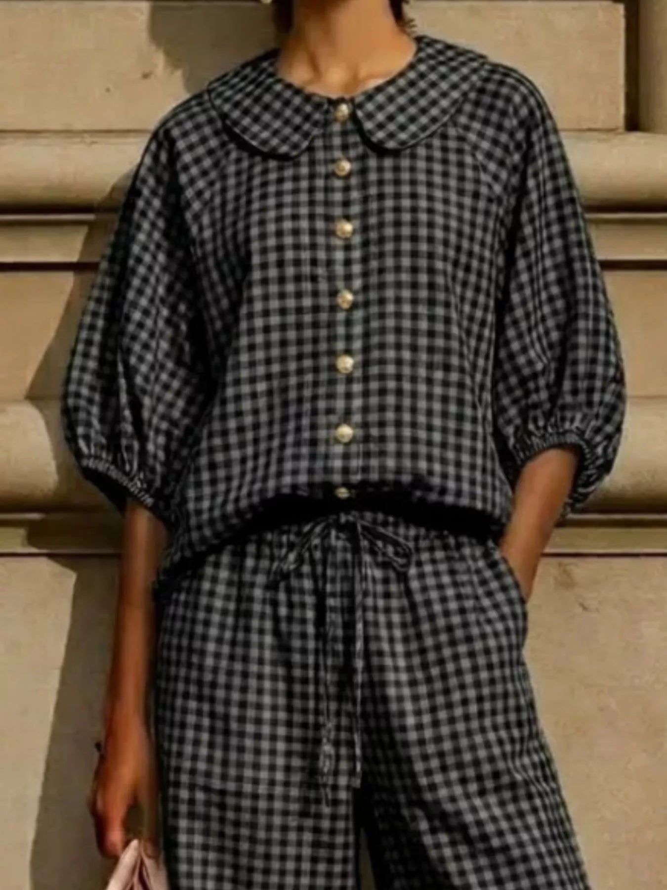 Black gingham plaid blouse and pants set, Peter Pan collar, gold buttons, tied elastic waist.