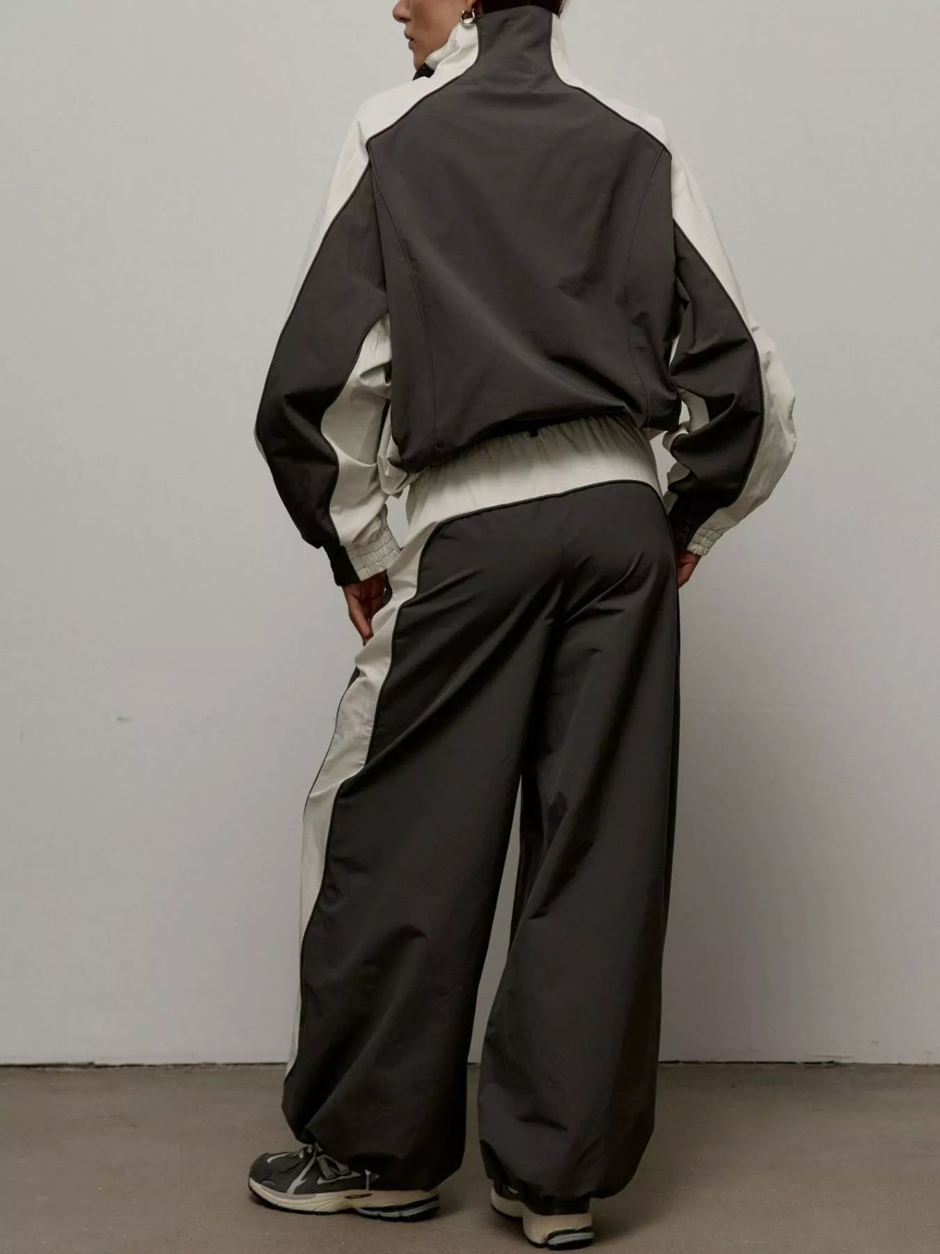 Color-block zip-up jacket and matching pants set, back view with black and light blocks.
