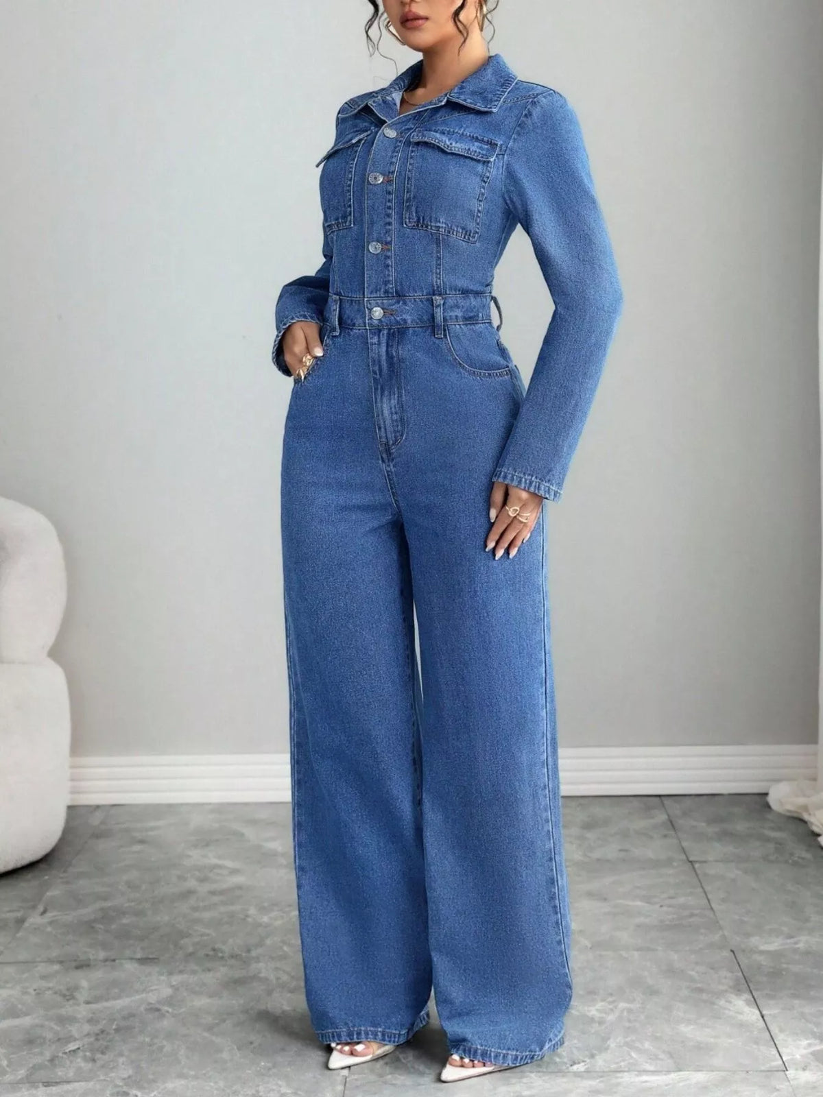 Blue denim button-front long-sleeve jumpsuit with chest pockets and wide-leg pants