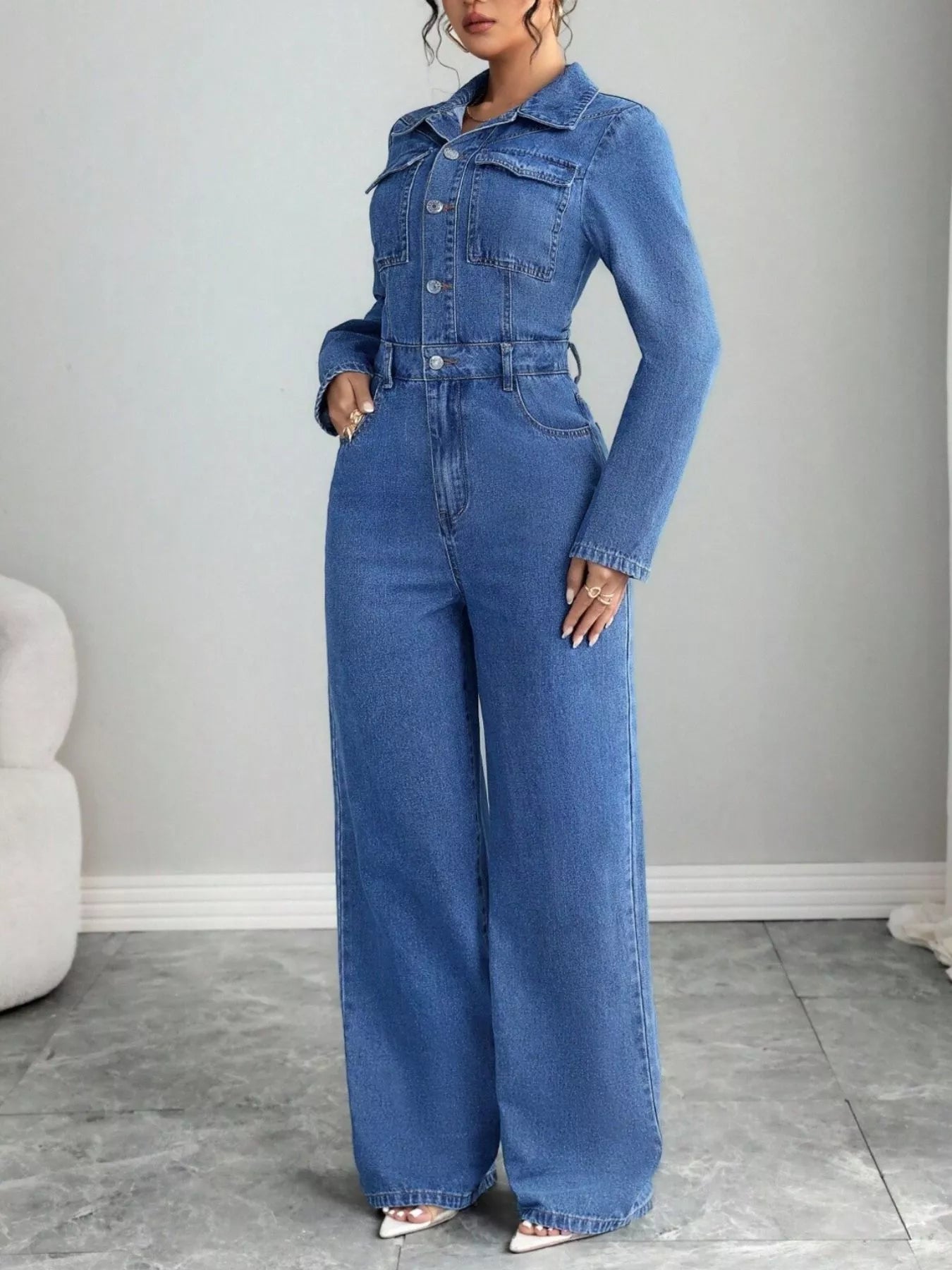 Blue denim button-front long-sleeve jumpsuit with chest pockets and wide-leg pants