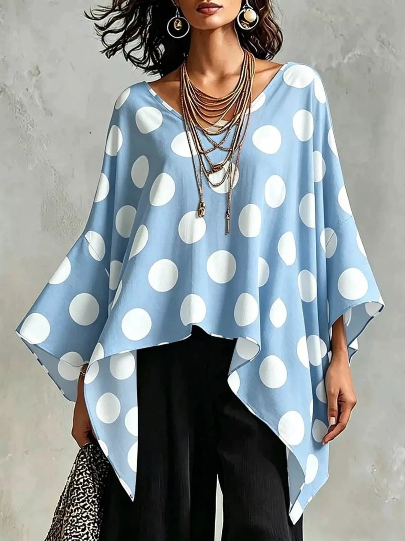 Light blue polka dot asymmetrical hem blouse with batwing sleeves and V-neckline.