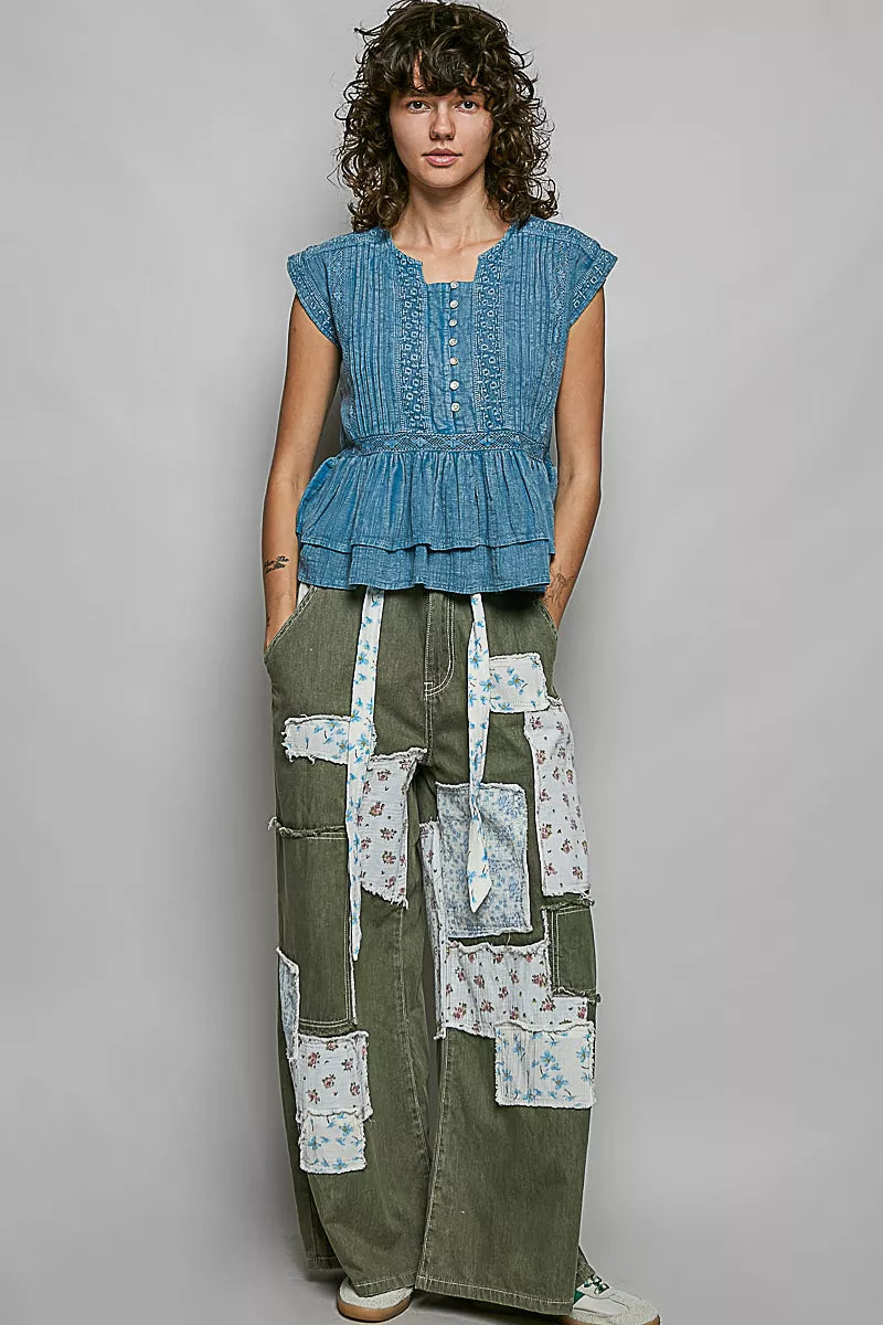 Denim blue sleeveless cotton blouse with pintuck texture, eyelet embroidery, tiered peplum
