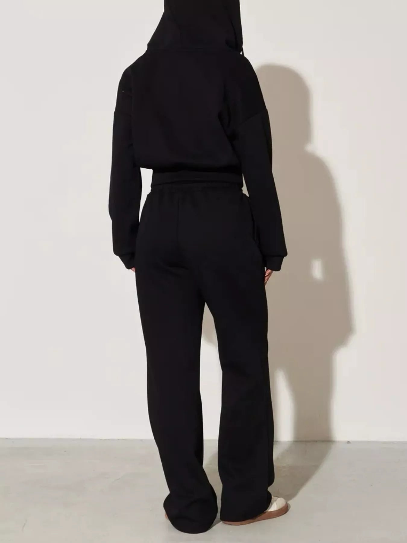 Black zip-up hoodie and wide-leg pants set, back view with long sleeves and hood