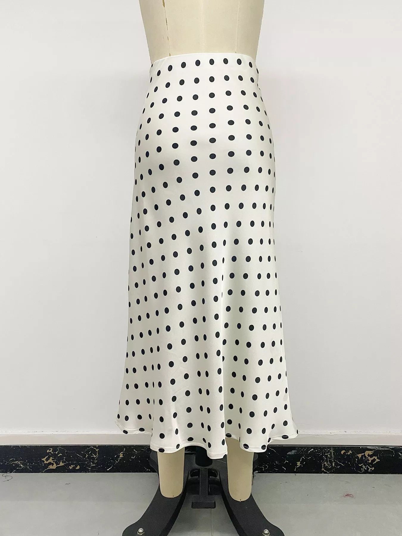 Cream polka dot midi skirt with black dots, mannequin front view with flared mid-calf hem