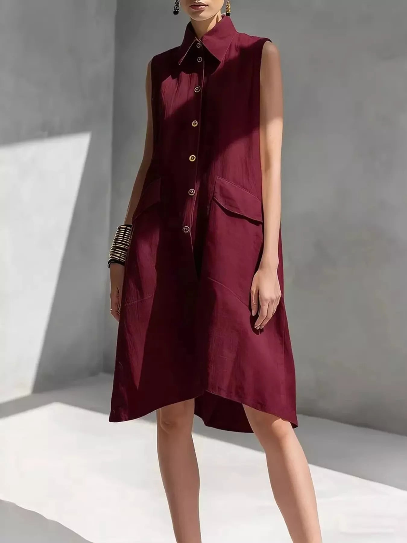 Wine red sleeveless button-front dress with pointed collar and patch pockets, knee length