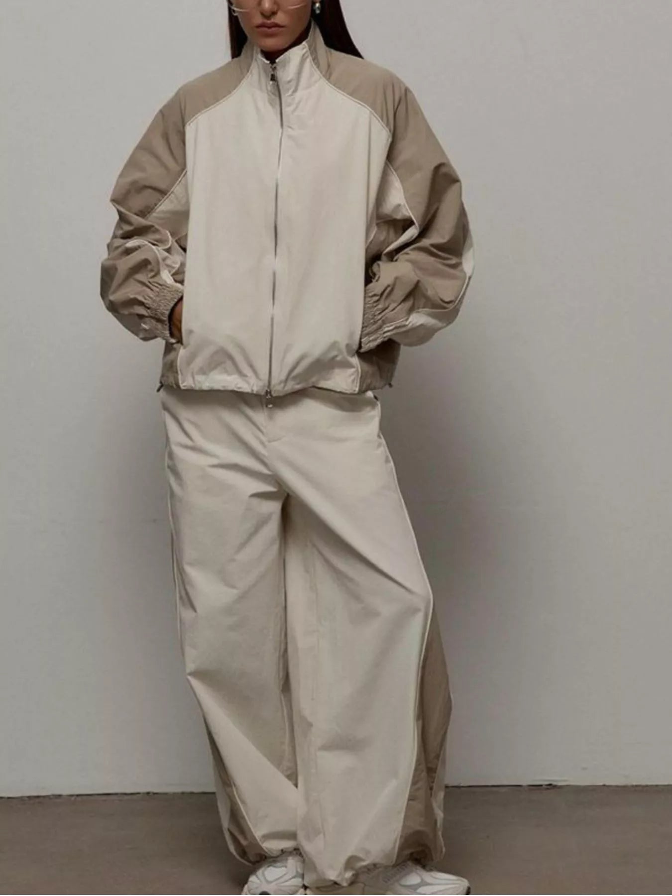 Zip-up color-block jacket and wide-leg pants set in light beige/cream, relaxed fit.