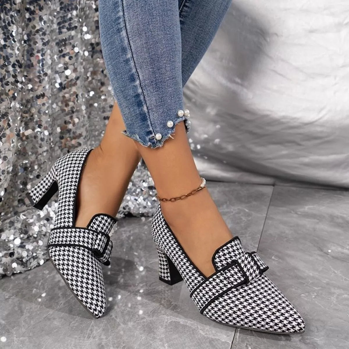 Point-toe block heel pumps in black-and-white houndstooth, ankle strap and heel
