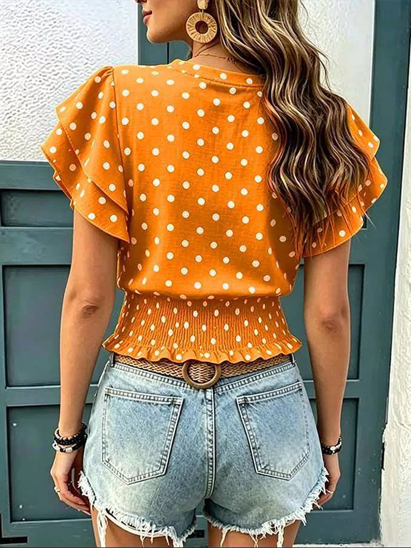 Orange polka dot blouse with back flutter sleeves and peplum waist