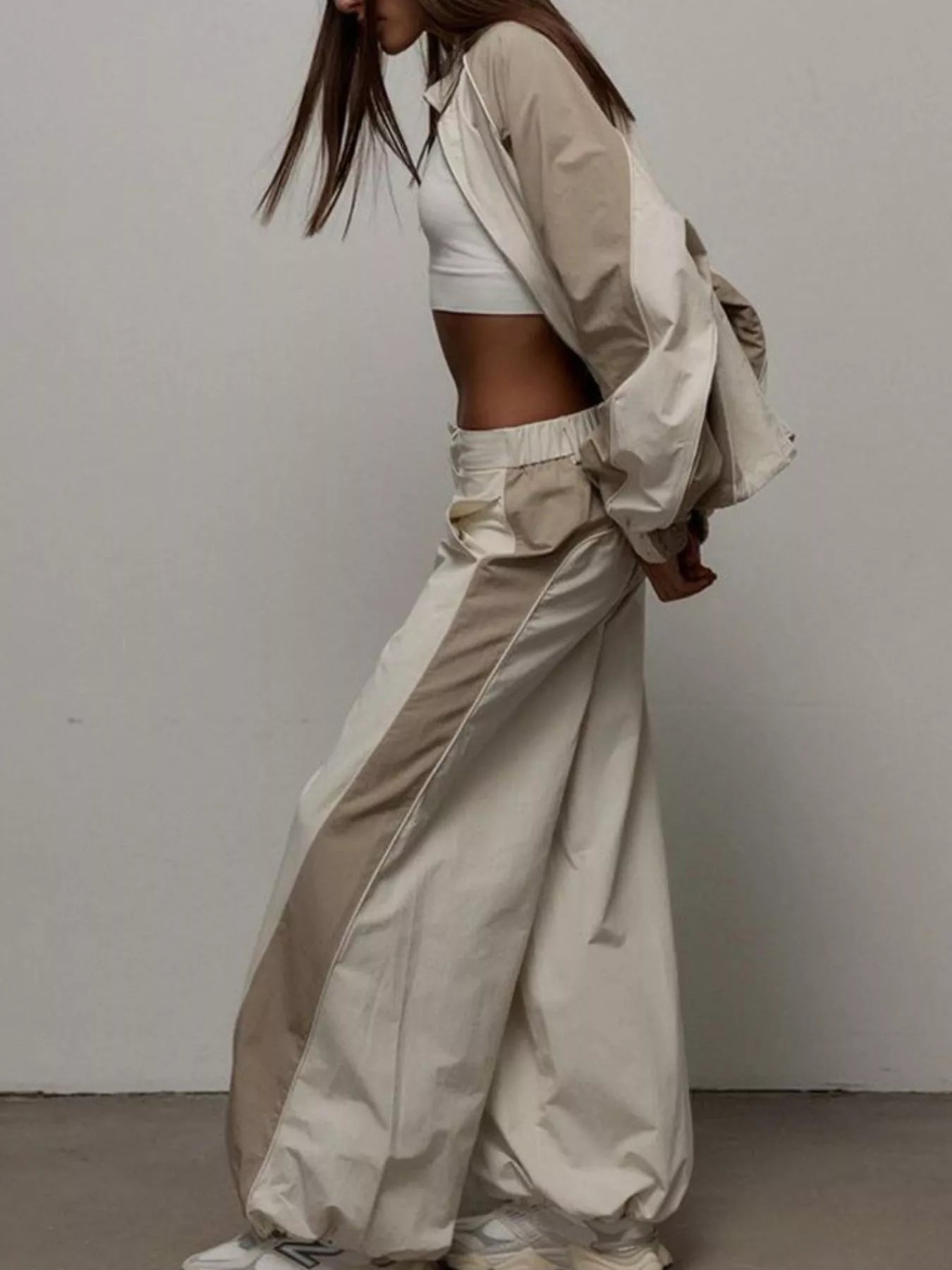 Color-block zip-up jacket and wide-leg pants set in light beige/cream, side profile.