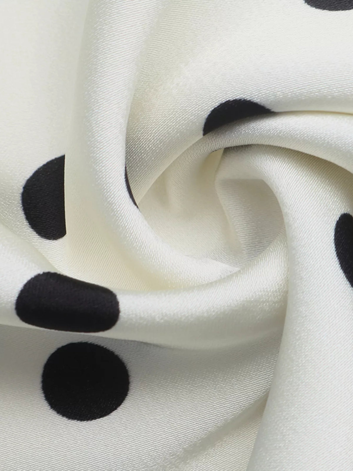 Beige midi skirt fabric close-up with black polka dots