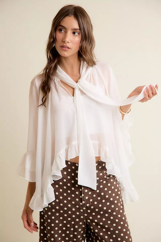 White sheer blouse with ruffle bell sleeves and tied bow-neck detail