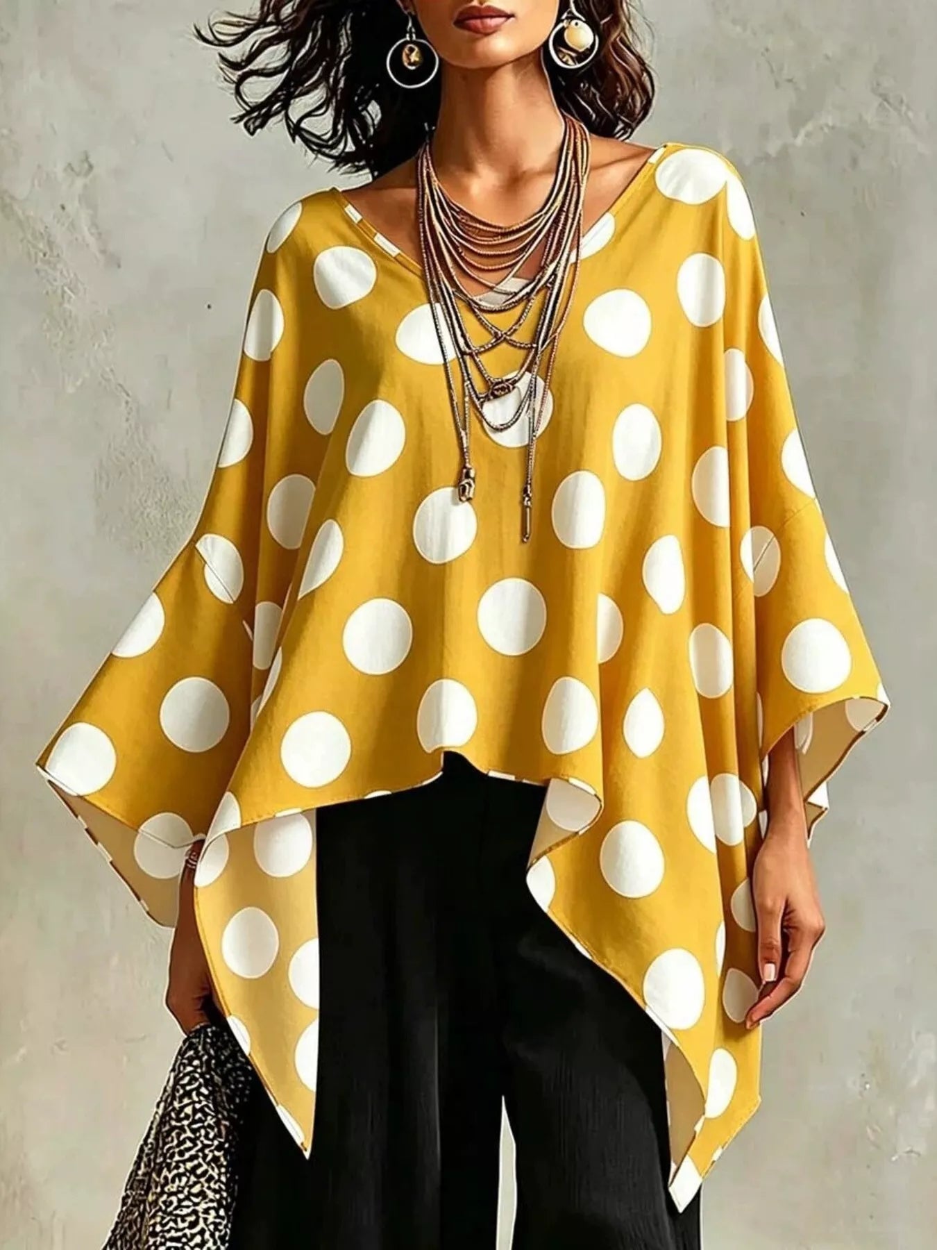 Gold polka dot asymmetrical hem blouse with batwing sleeves and draped front.
