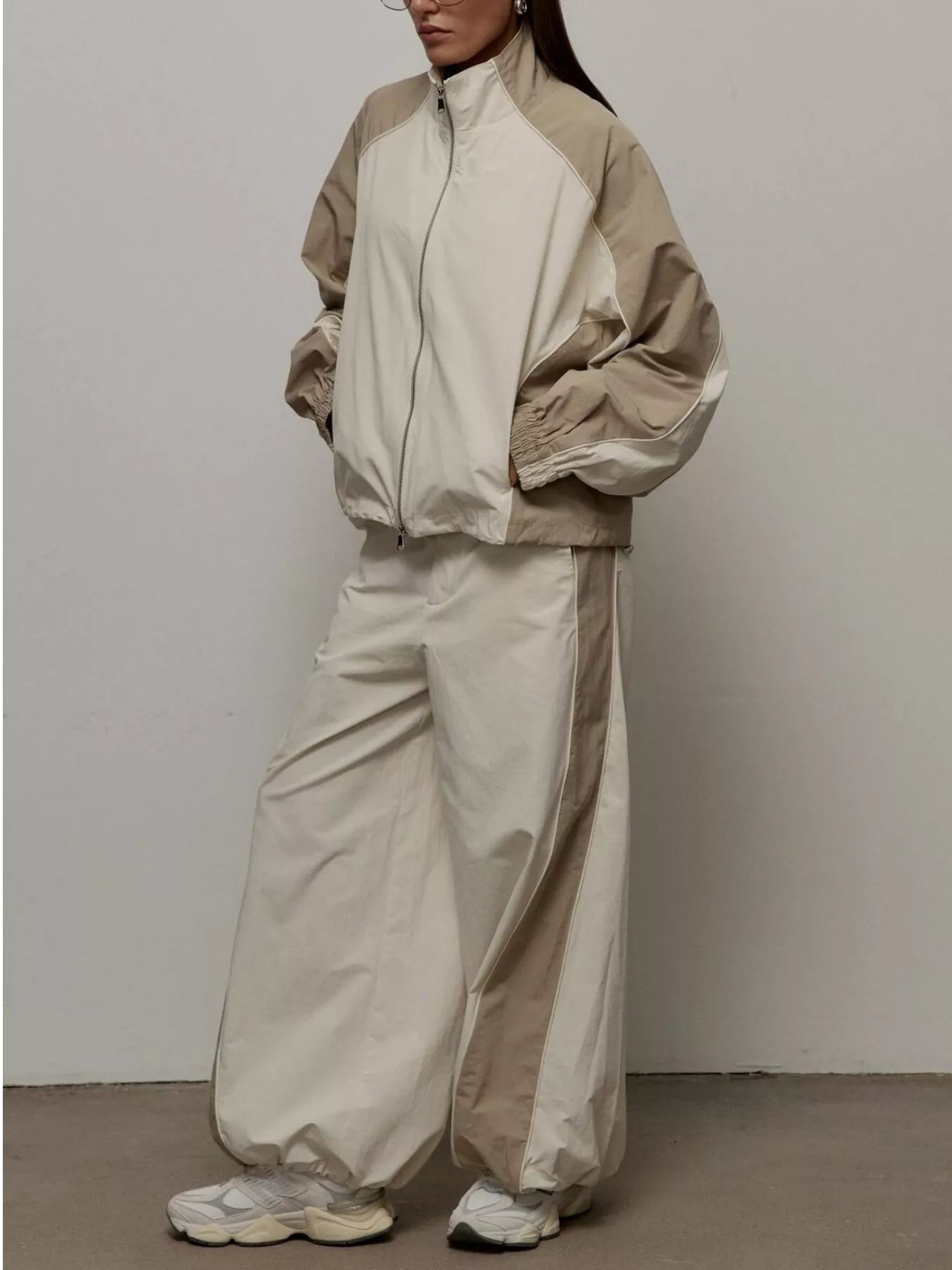 Color-block zip-up jacket and wide-leg pants set in light beige/cream, full zip.