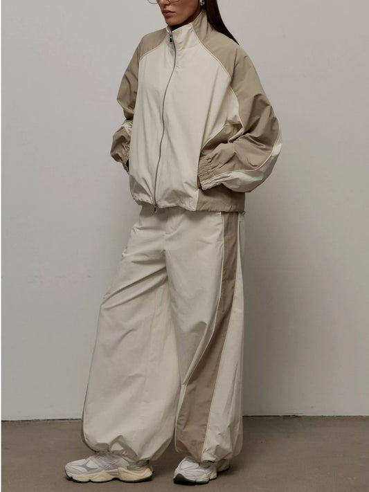 Color-block zip-up jacket and wide-leg pants set in light beige/cream, full zip.