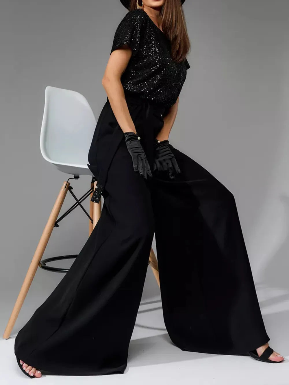 Side view: black sequin short-sleeve wide-leg jumpsuit with tied waist detail