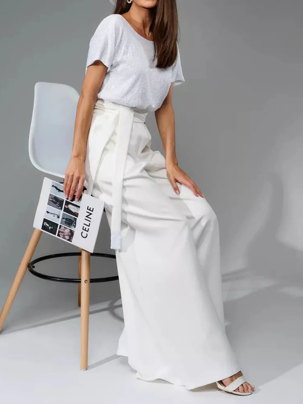 White short-sleeve jumpsuit with tie waist detail and flowing wide-leg legs.