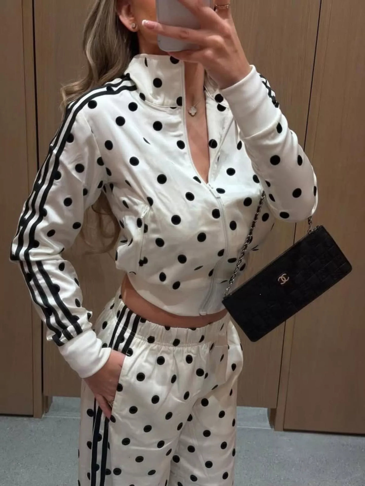 White polka-dot zip jacket and pants set with black trim stripes on sleeves and cuffs