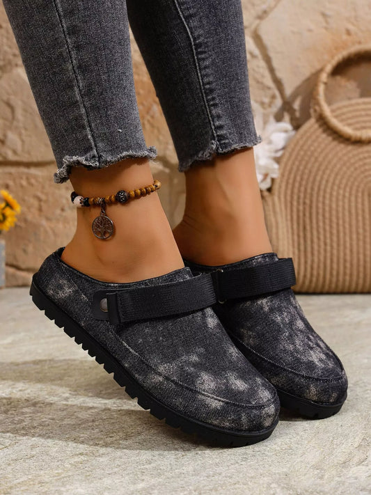 Black round-toe flat slip-ons with adjustable strap and cushioned sole