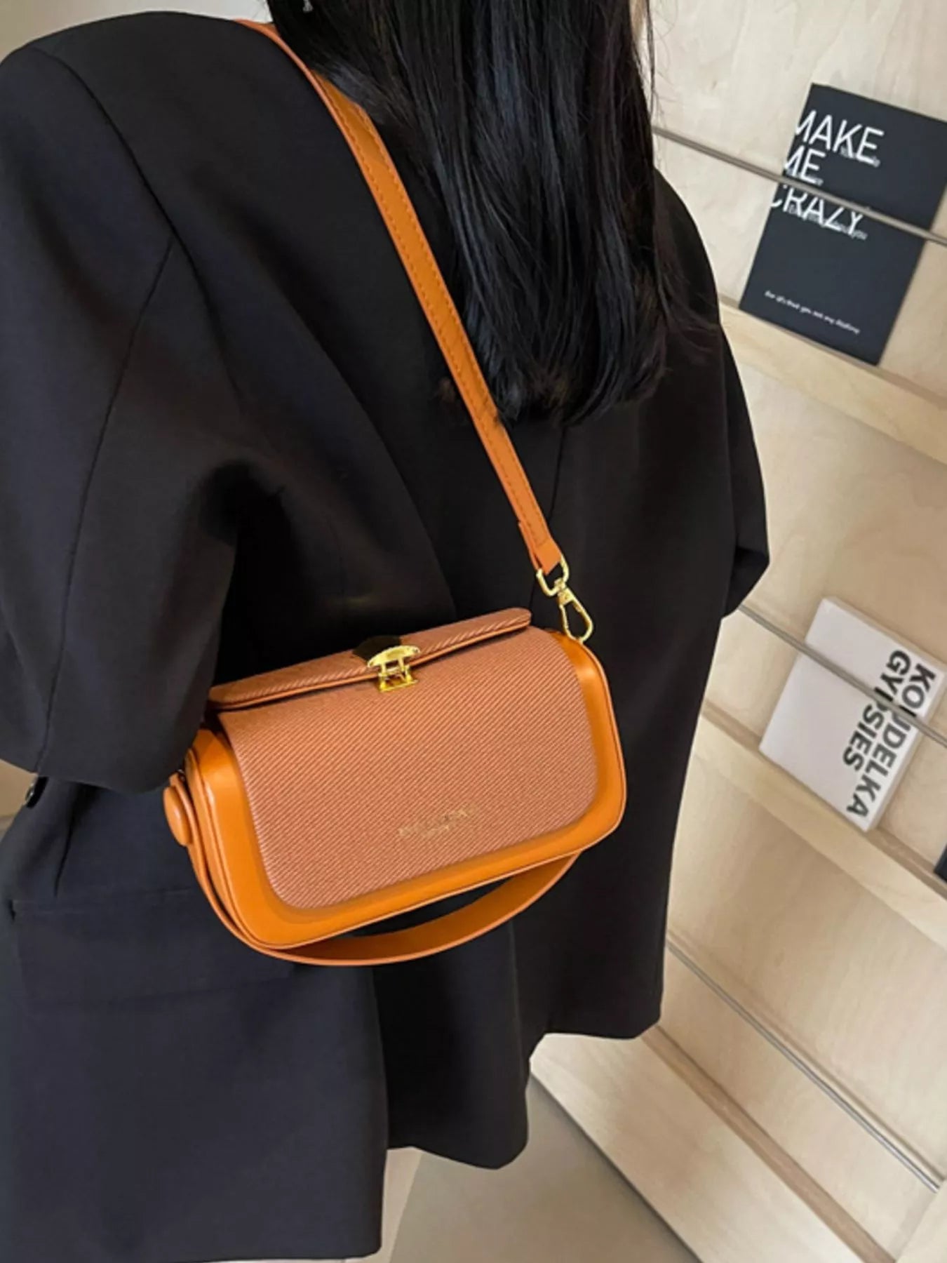 Brown crossbody bag with textured flap, gold-tone lock, and adjustable strap