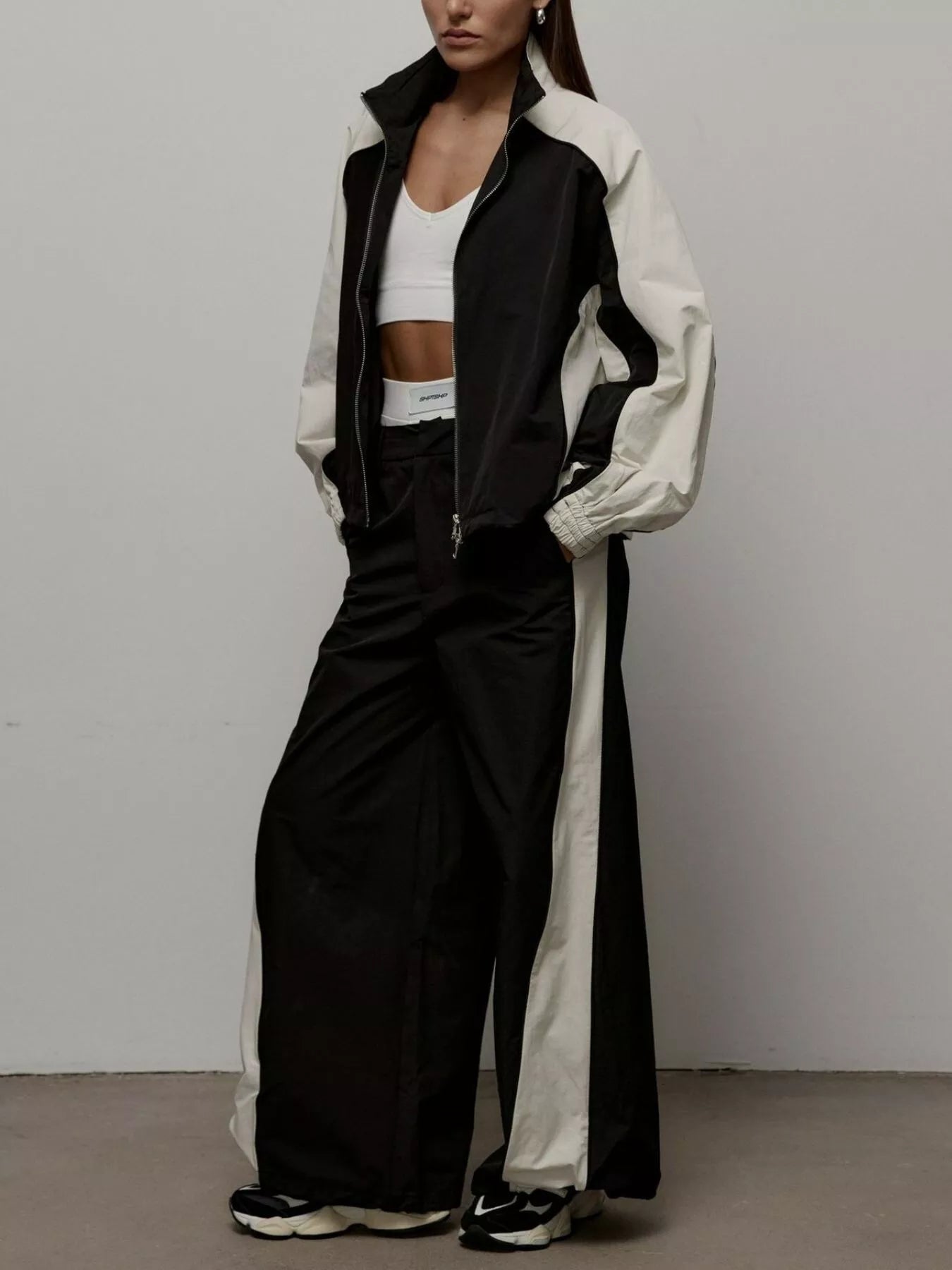 Color-block zip-up jacket and wide-leg pants set in black with light contrast panels.