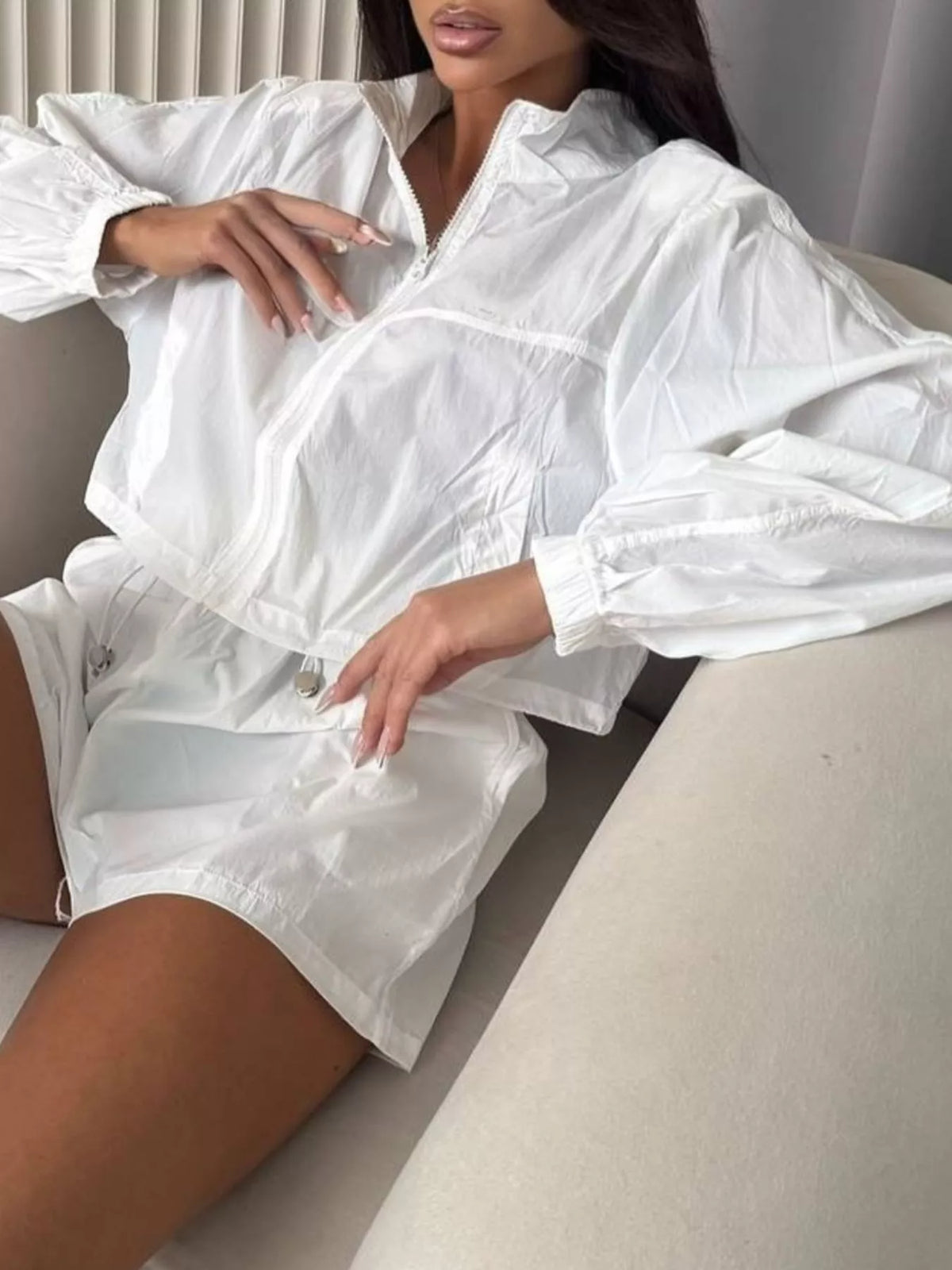 White zip-up long sleeve outerwear and elastic-waist shorts set, side view