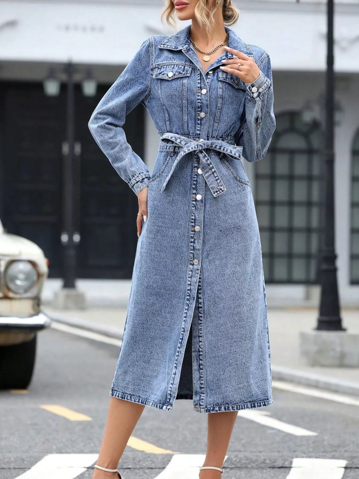 Light blue denim belted long-sleeve dress with button placket and wrap-tie waist.