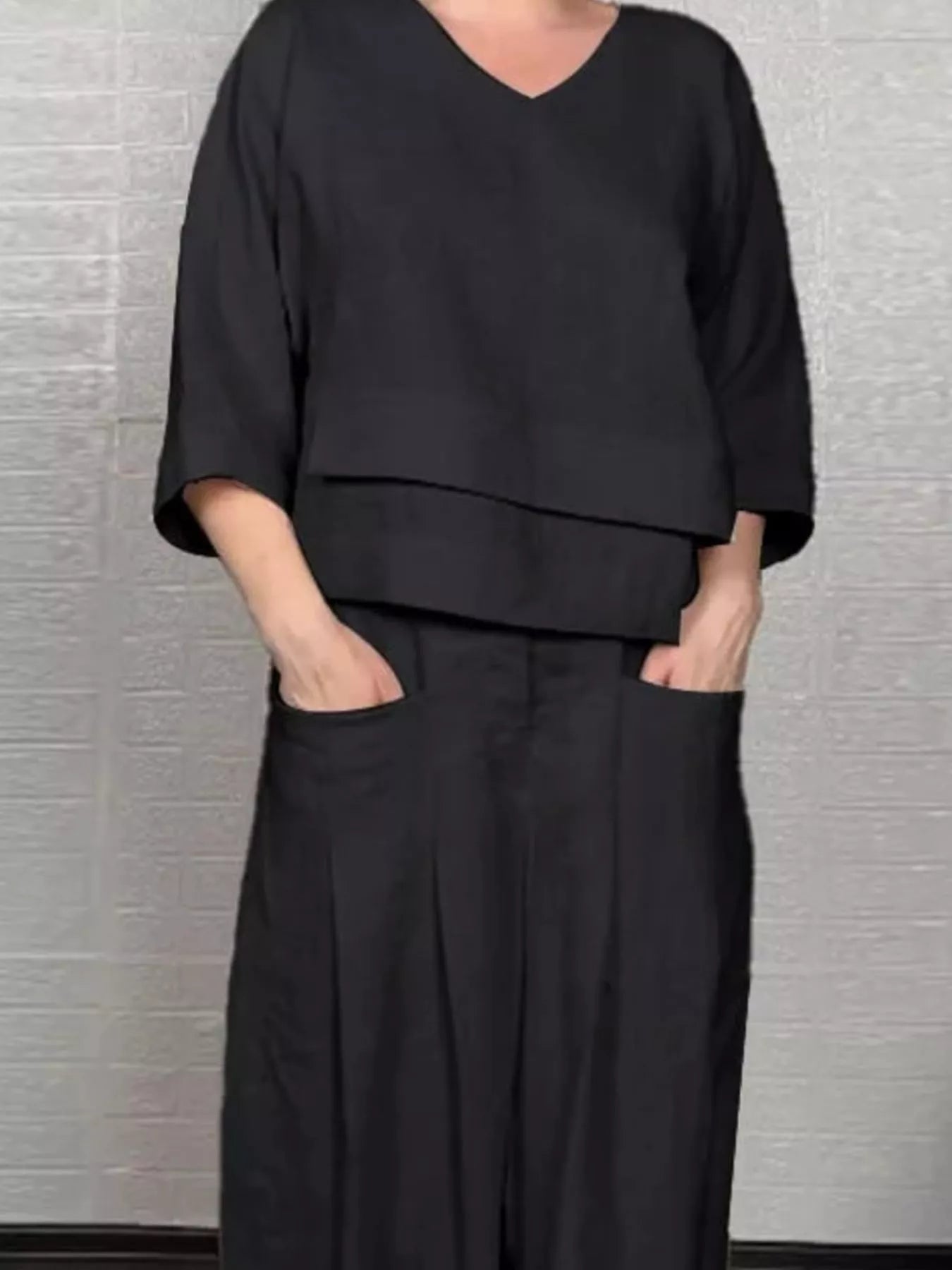 Black V-neck long sleeve top and wide-leg pants set, relaxed fit, folded sleeve cuffs.