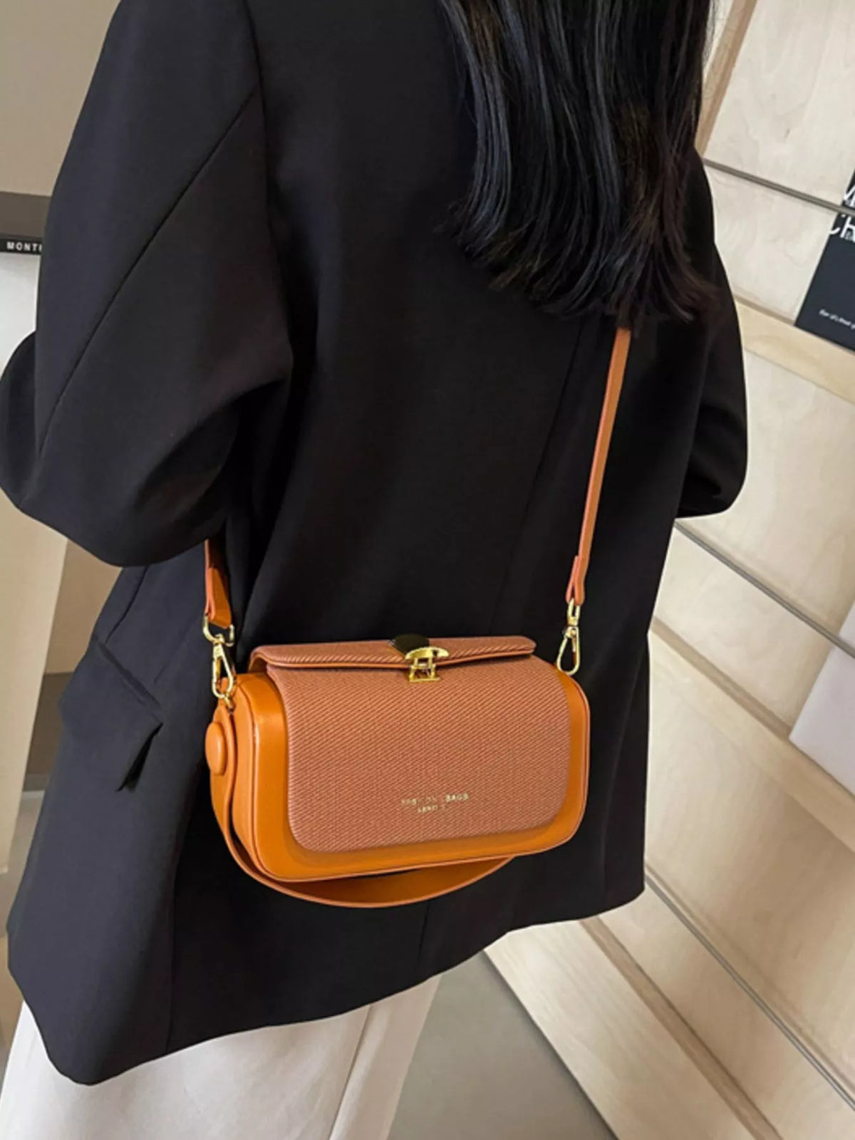 Brown mini crossbody bag with textured front flap and adjustable shoulder strap