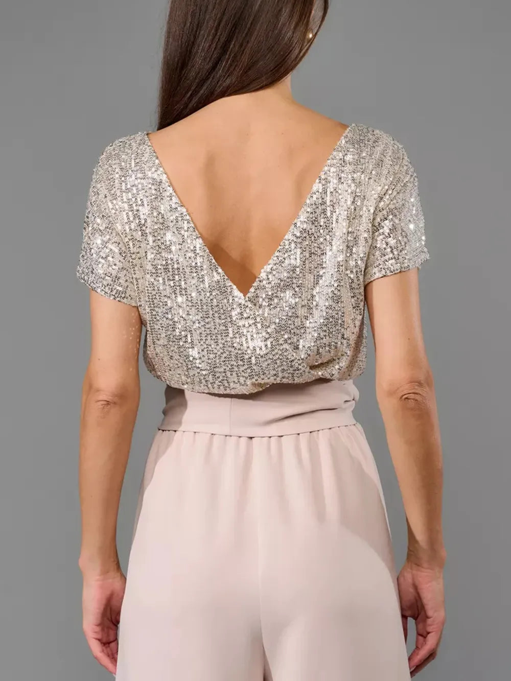 Back view: silver sequin V-back short-sleeve wide-leg jumpsuit with blush waist