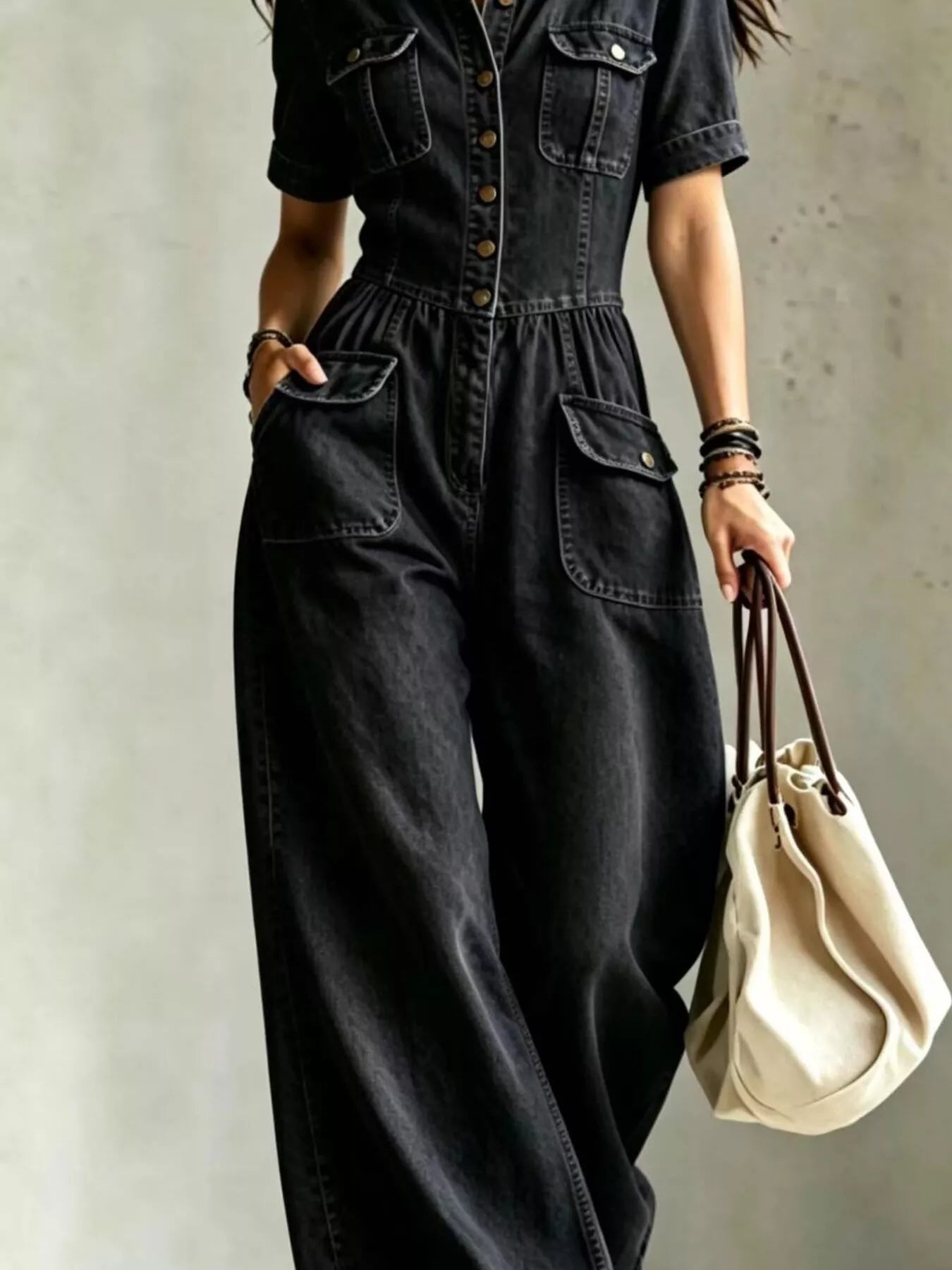 Black denim wide-leg jumpsuit with chest pockets and cinched waist