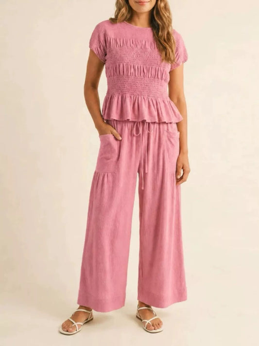 Pink smocked peplum top and wide-leg pants set with tiered ruffle hem and drawstring waist
