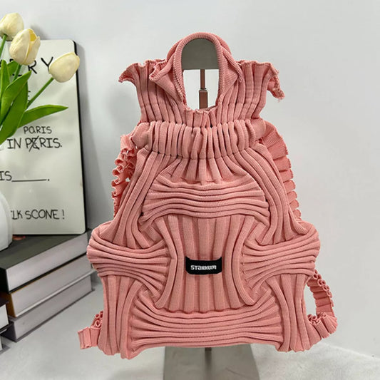 Pink textured knit backpack with ruffled body, top handles, front patch logo