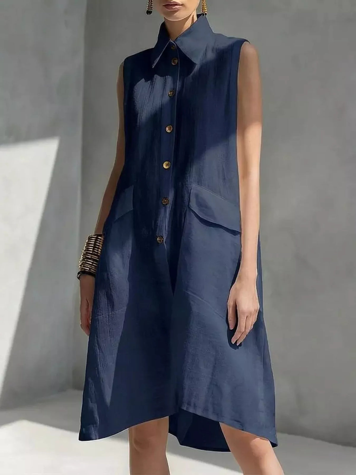 Navy sleeveless button-front dress with pointed collar and patch pockets, knee length