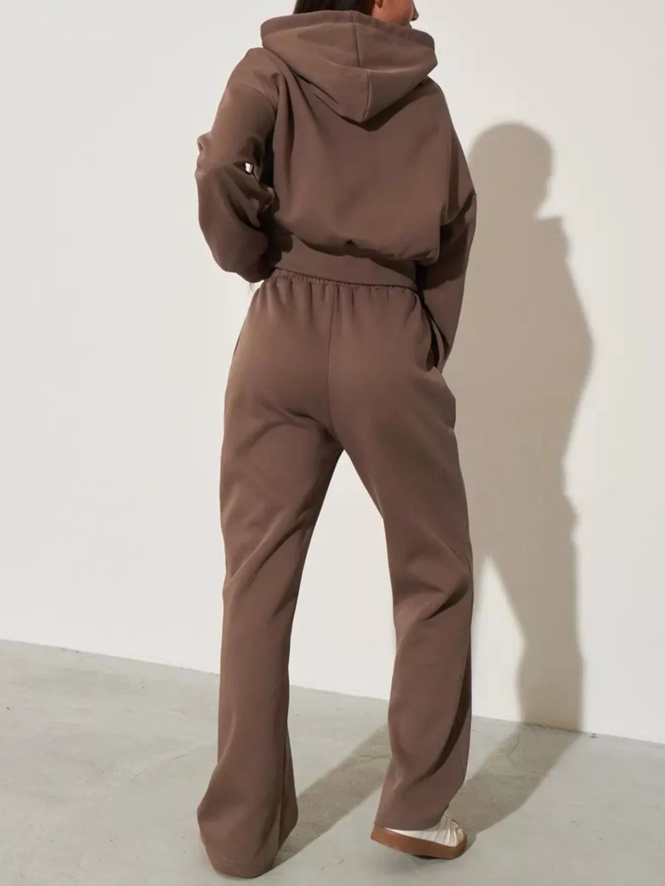 Brown zip-up hoodie and wide-leg pants set from the back with hood and gathered waist