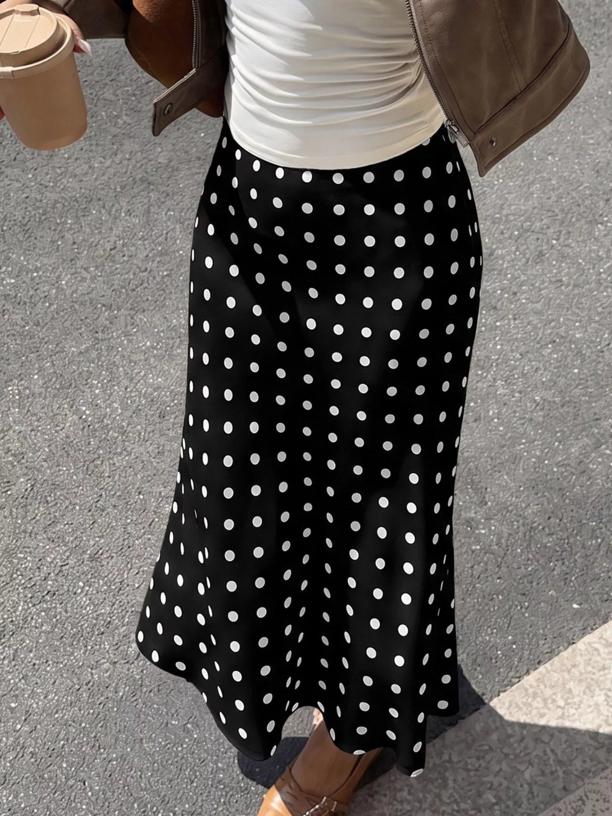 Black midi skirt with evenly spaced white polka dots and soft pleated look