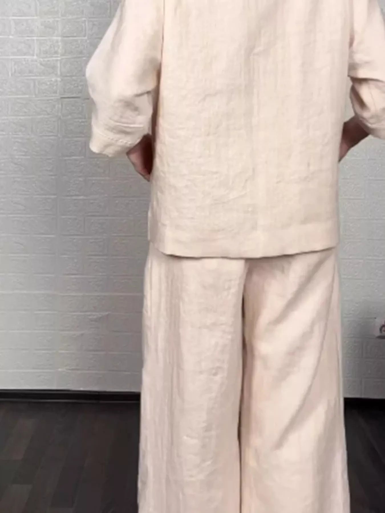 Apricot V-neck long sleeve top and wide-leg pants set, close-up of layered hem.