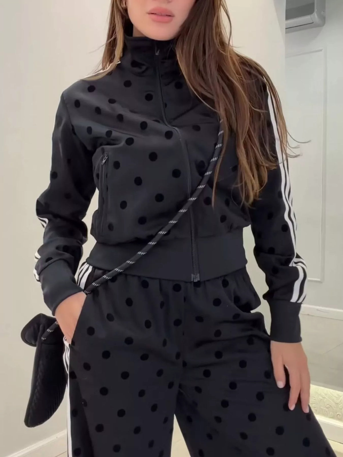 Black polka dot zip-up jacket and pants set with striped sleeve accents