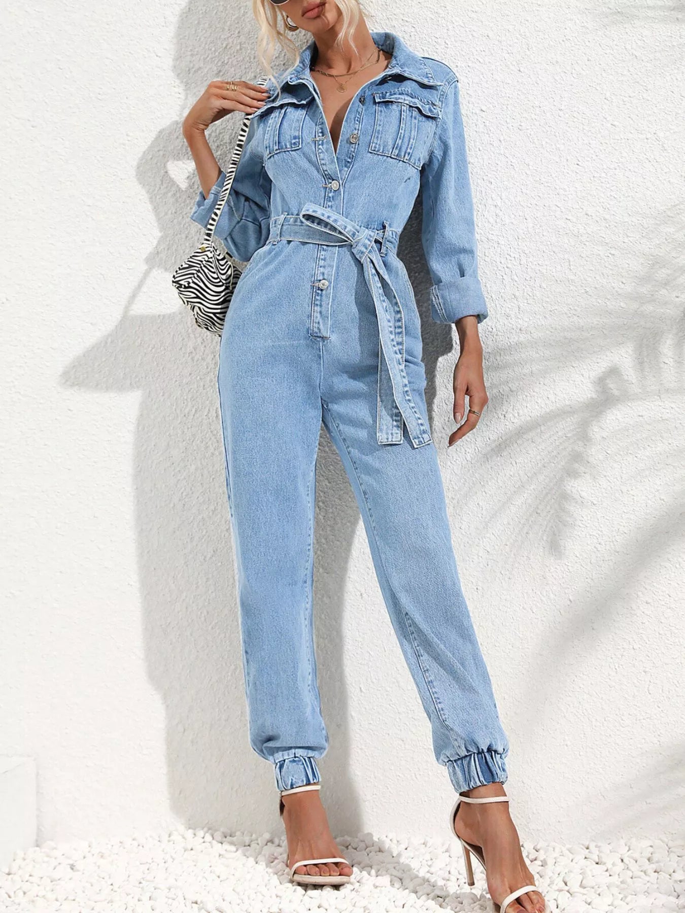 Medium blue denim button-front jumpsuit with waist tie belt and collared neckline