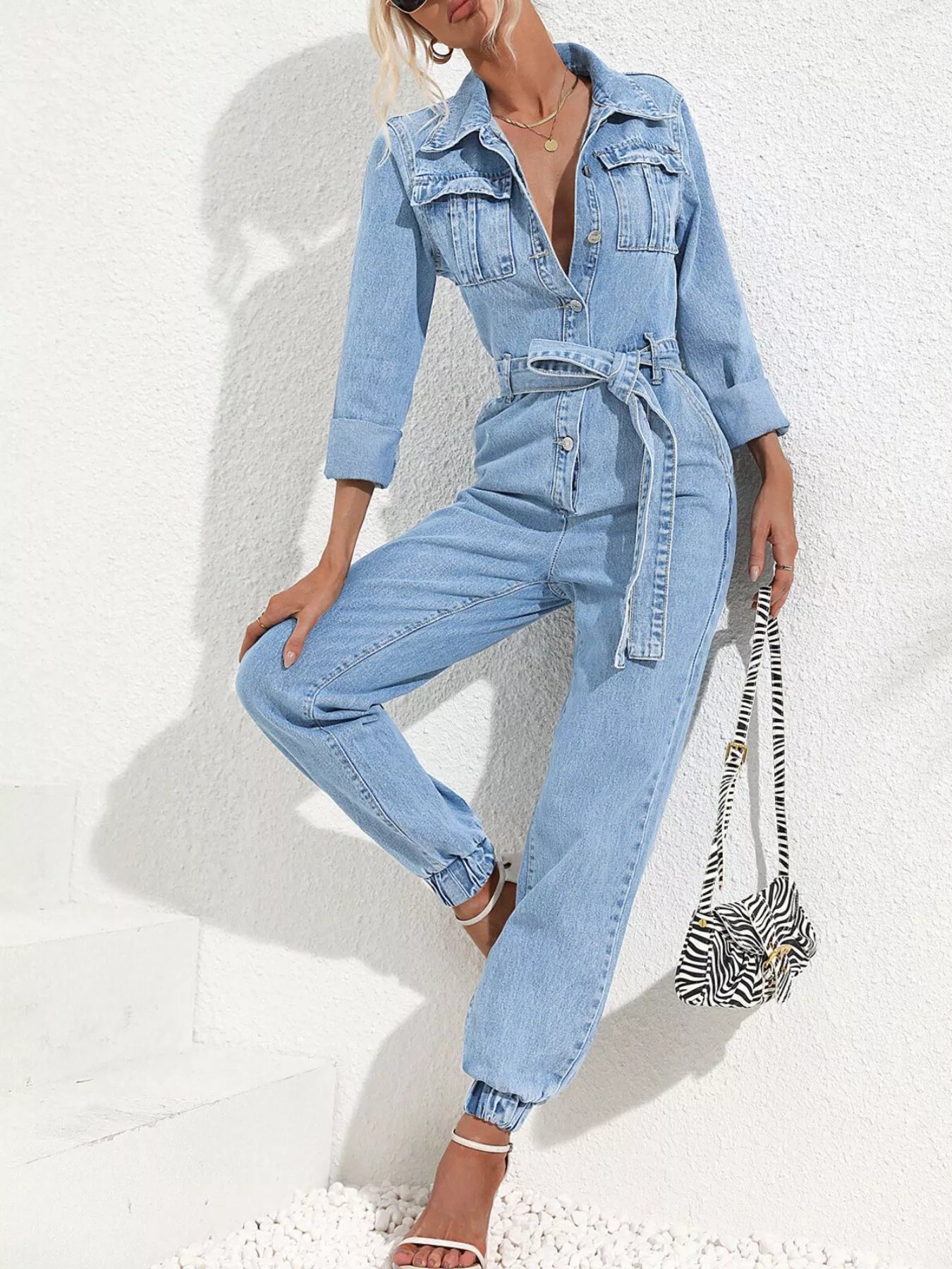 Medium blue denim button-front jumpsuit with waist tie belt and loose straight legs