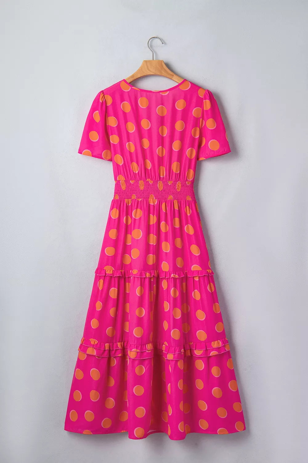 Hot pink polka dot tiered midi dress with gathered smocked waist and short sleeves