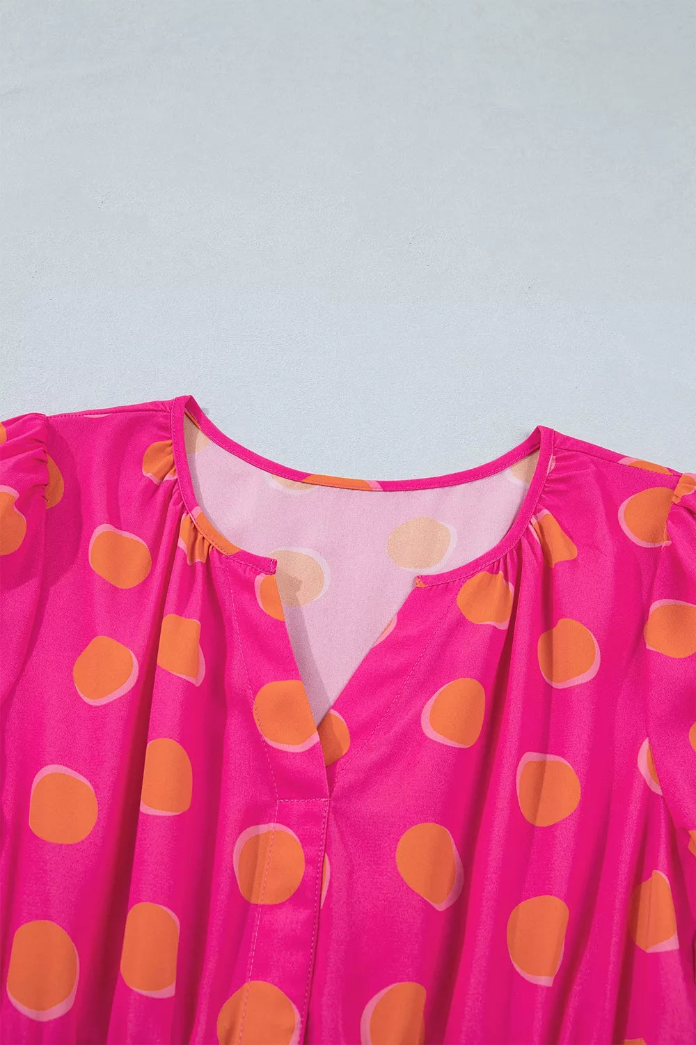 Hot pink polka dot dress bodice with V-neck and gathered smocked waist