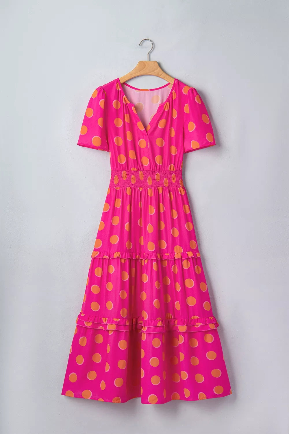Hot pink polka dot tiered midi dress with V-neck, short sleeves, smocked waist
