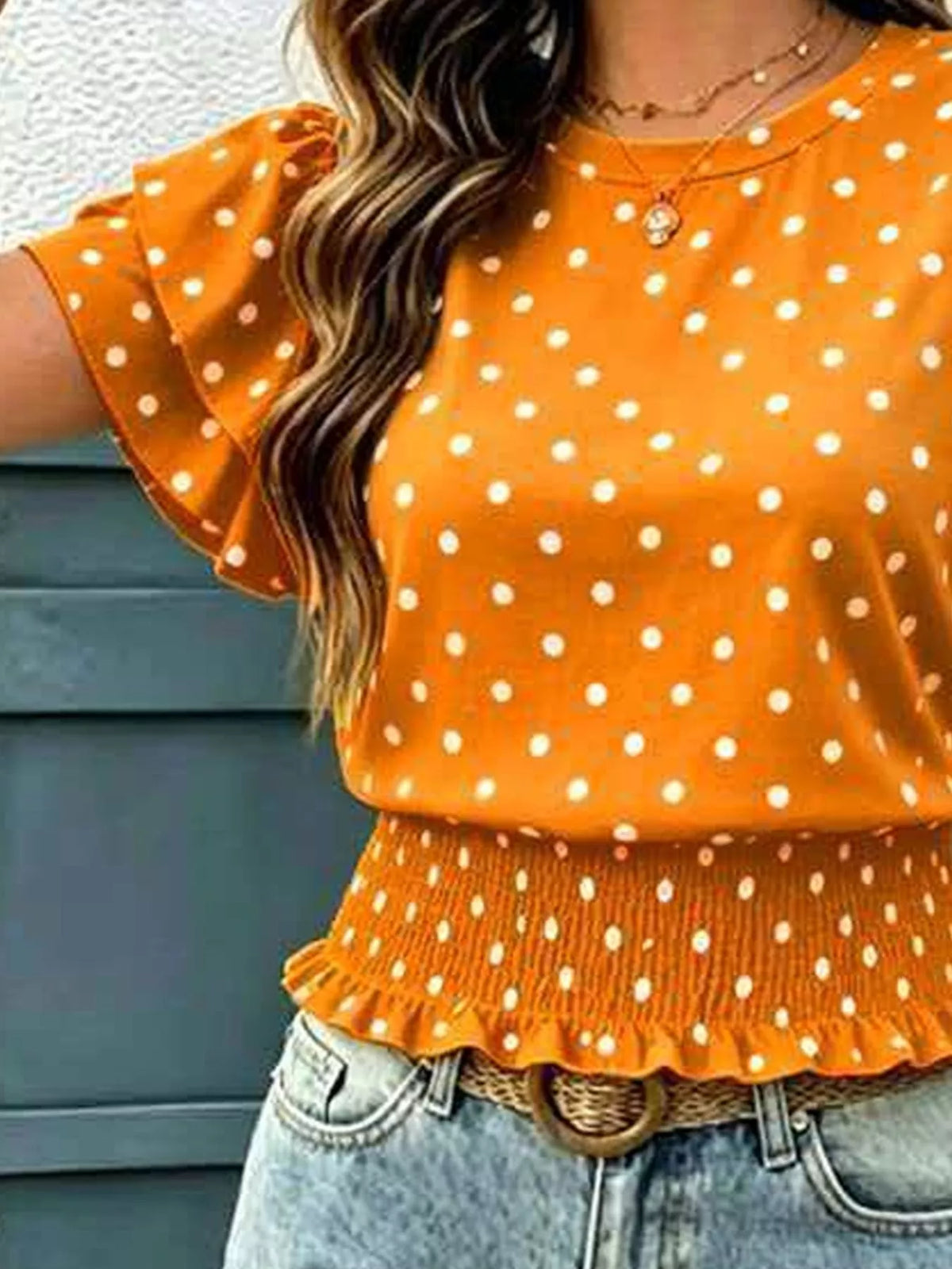 Orange polka dot blouse with ruffle sleeves and tiered peplum hem
