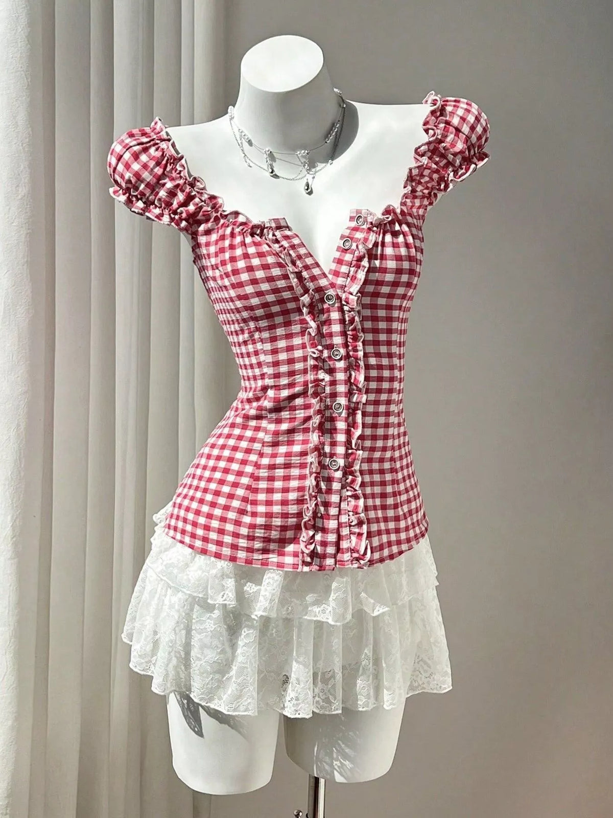 Red gingham blouse with frilled cap sleeves, button front, and ruffled peplum hem