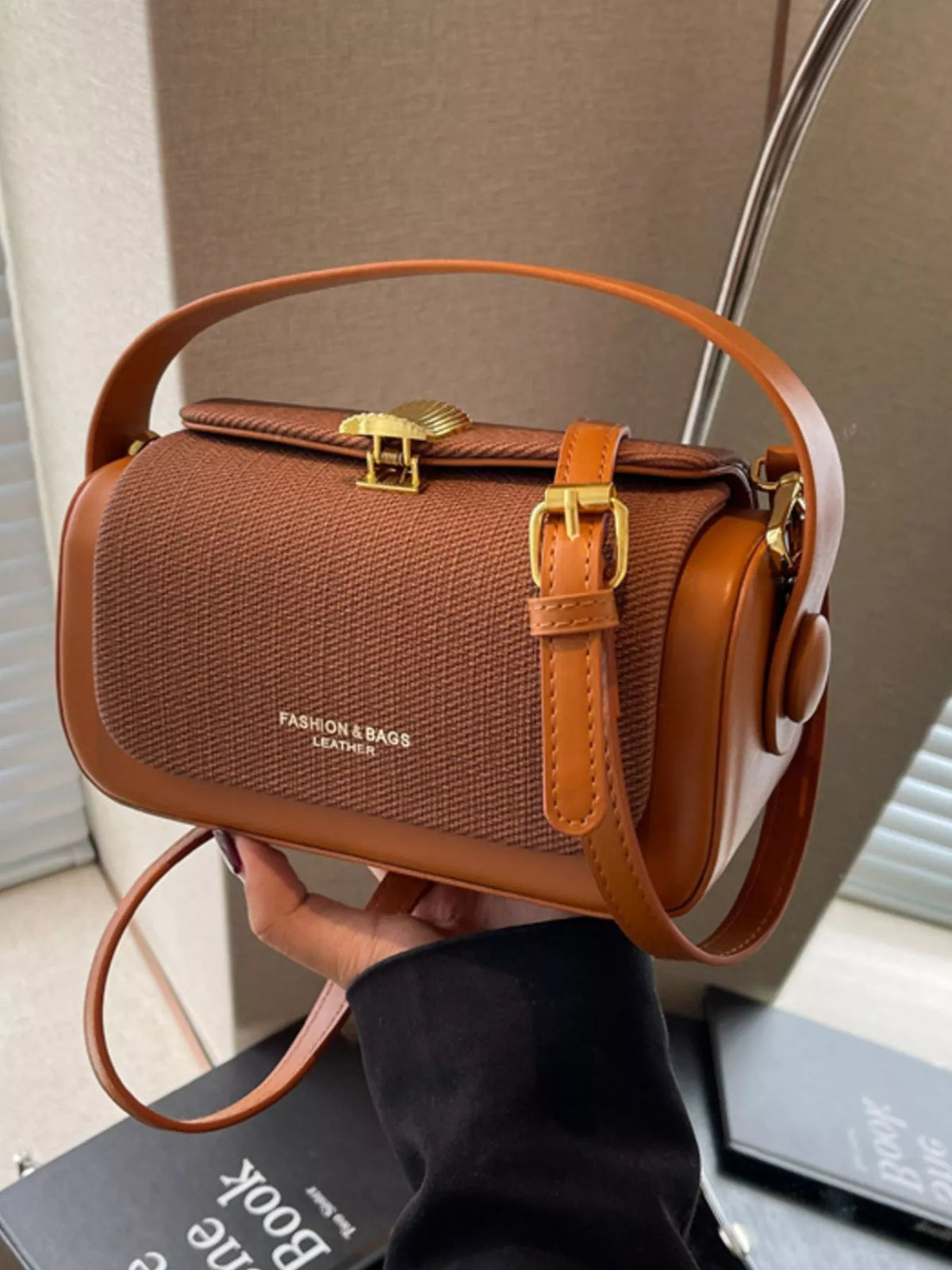 Brown structured crossbody bag with textured body, flap clasp, and adjustable strap